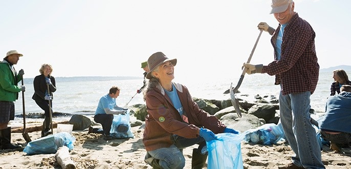 A woman cleaning up a beach.