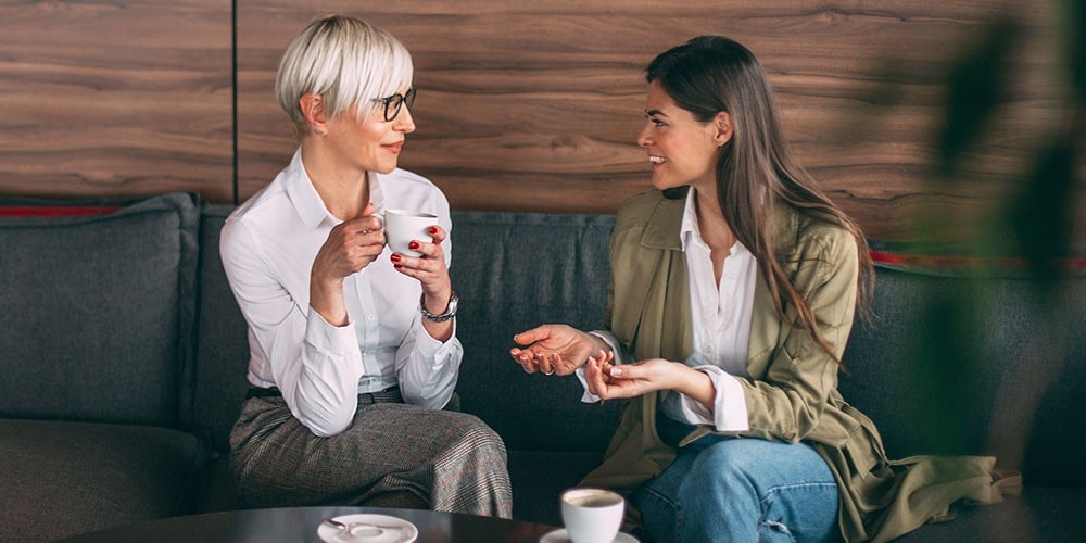 Deux femmes bavardent en prenant un café